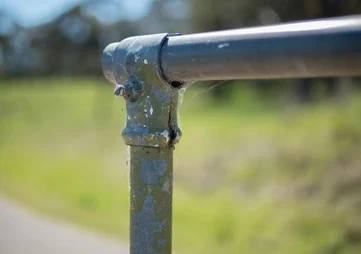 Corroded old galvanized steel pipe joint with visible rust and wear.
