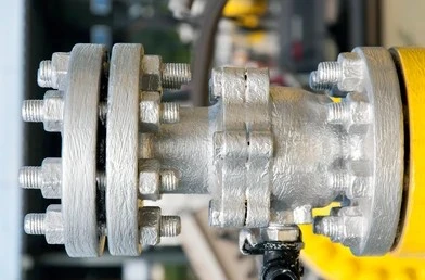 Close-up of a heavy-duty flanged water pressure regulator valve with bolted metal fittings.