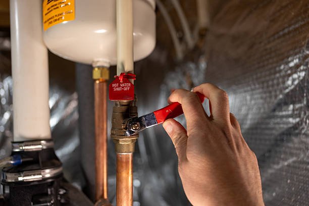 Turning off the water heater shut-off valve before flushing tank sediment.